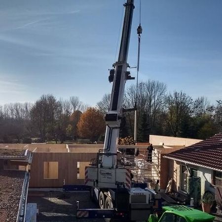 Baustelle eines Holzhauses mit Kran und Bauarbeitern - Wohnhaus II