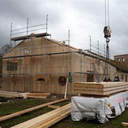 Holzgebäude im Bau mit Bauholz im Vordergrund - Spielscheune Kloster Veßra