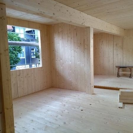 Innenausbau mit Holzwänden und großem Fenster - Aufstockung Geschäftshaus Ilmenau