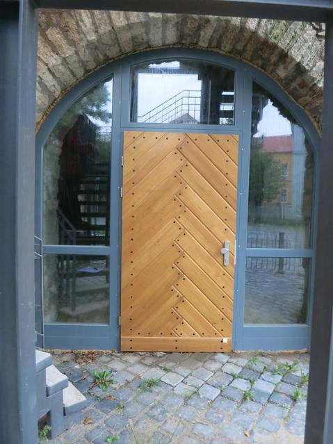 Impression - Eine hölzerne Tür in einem gewölbten Gebäude