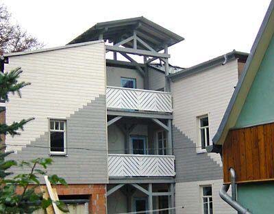 Impression - Mehrfamilienhaus mit Holzfassade und zwei Balkons