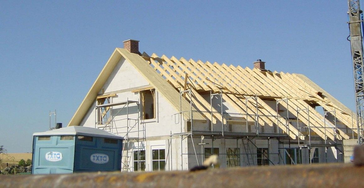 Ein Haus, wo ein Holzdach gebaut wird.